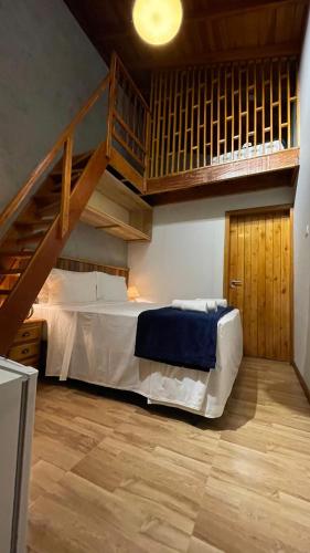 a bedroom with a bed with a wooden staircase at Espaço Villa Verde in Ibiúna