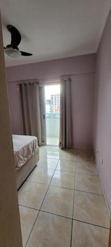 a bedroom with a bed and a tiled floor at Apartamento Boqueirão - Praia Grande in Praia Grande