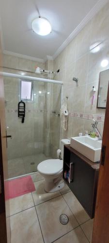 a bathroom with a shower and a toilet and a sink at Apartamento Boqueirão - Praia Grande in Praia Grande