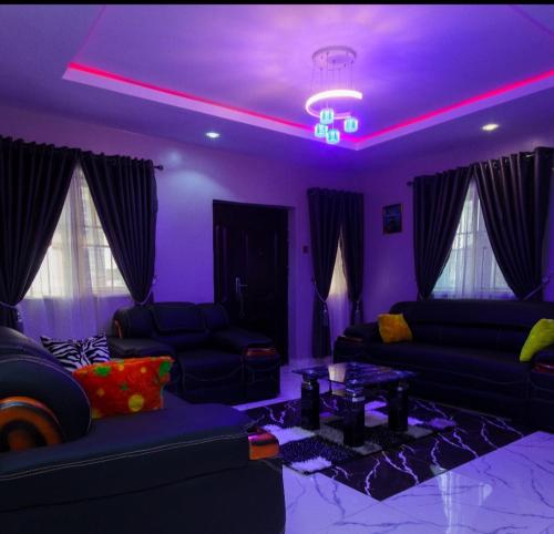 a purple living room with couches and a table at D'EXQUISITE APARTMENTS in Ibadan