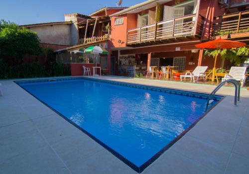 a large blue swimming pool in front of a house at Pousada Irashai in Juquei