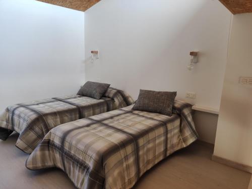 a bedroom with two beds and a couch at VUELVE apartamentos in Fuente de Cantos