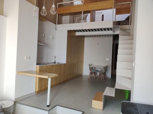a living room with a staircase and a table at VUELVE apartamentos in Fuente de Cantos