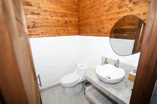 a bathroom with a white toilet and a sink at Eco Hotel La Italia- Hotel Venecia, Antioquia in Venecia