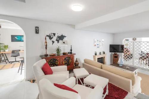 a living room with white furniture and a fireplace at GeDel Ma Zen Resort in Poris de Abona