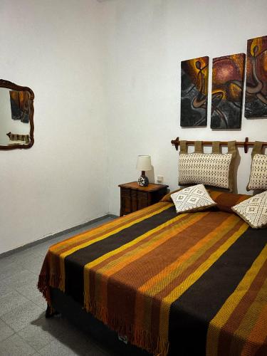 una camera da letto con letto e quadri alle pareti di El Ocaso Villa Giardino a Villa Giardino