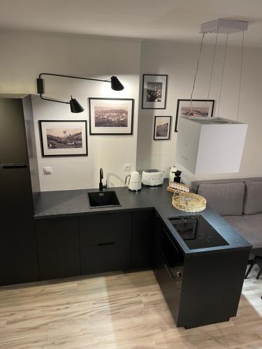 a kitchen with a black counter top and a sink at Apartmánový dům Jánský sen in Janske Lazne