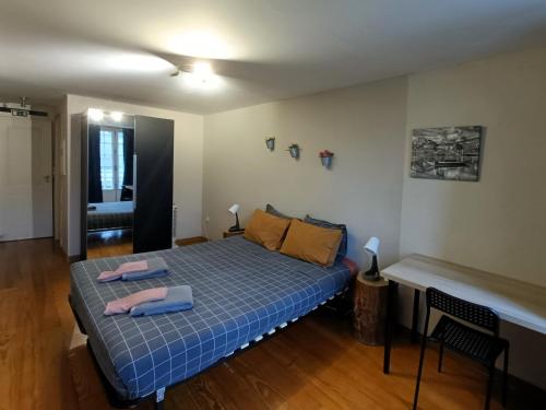 1 dormitorio con 1 cama azul y 2 toallas en AlfandegaPorto Apartments, en Oporto