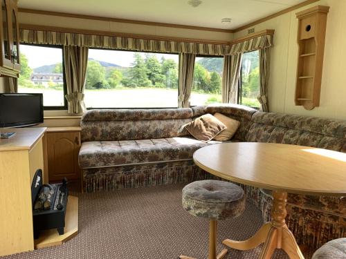 a living room with a couch and a table at Sandpiper Caravan in Onich