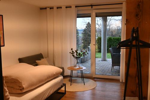 Schlafzimmer mit einem Bett und einer Tür zu einer Terrasse in der Unterkunft Altholzapartment in Kempten in Waltenhofen