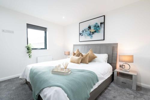 een witte slaapkamer met een groot bed en 2 ramen bij Stunning 2 Bedroom Apartment - 5 mins walk to center in Belfast