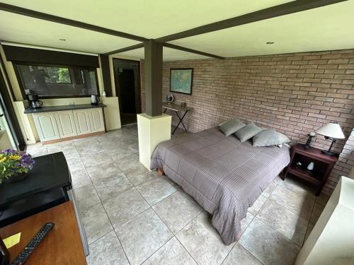 um quarto com uma cama e uma parede de tijolos em Casita de montaña em Alto de los Chantos