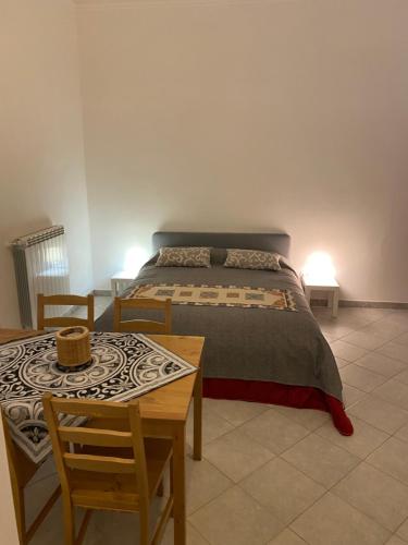 een slaapkamer met een bed en een tafel en stoelen bij Casa Marconi 3, centrale, parking gratuit en rue. in Aragona