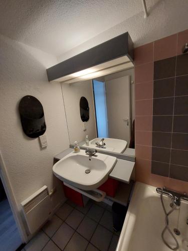 uma casa de banho com um lavatório, um espelho e uma banheira em RESIDENCE LE RUITOR ARCS 1800 Duplex dernier étage 6 personnes vue panoramique classé 4 Cristaux Paradiski em Arc 1800