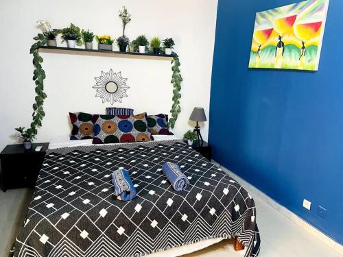 una camera da letto con un letto con una parete blu di Chez Diogoye a Dakar