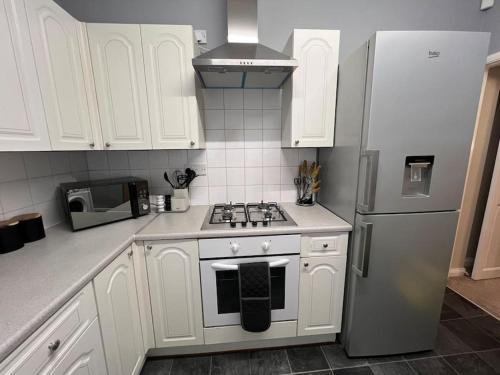 a white kitchen with a stove and a refrigerator at Stylish & Centrally Located in Chester-le-Street