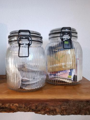 two glass jars sitting on top of a wooden shelf at Altholzapartment in Kempten in Waltenhofen