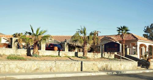 a building with palm trees in front of it at Costa del Sol Hotel & Sportfishing in Bahía de los Ángeles