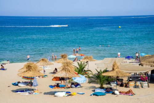 a group of people on a beach with umbrellas at Hotel Miramar Sozopol in Sozopol