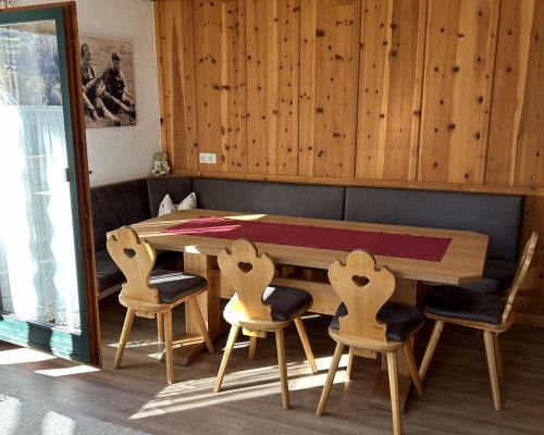 una mesa de madera y sillas en una habitación en Ferienhaus Frühlingsheim, en Sölden