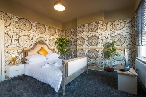 ein Schlafzimmer mit einem großen Bett und einer Wand mit Mustern in der Unterkunft Stunnning 4 Bed House Hot Tub Sky Tv Pool Table in London