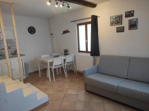 a living room with a couch and a table at Gîte les petites bruyères in Veneux-les-Sablons