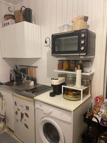une cuisine avec un micro-ondes et un lave-linge dans l'établissement APP Cozy en plein coeur de Paris, à Paris