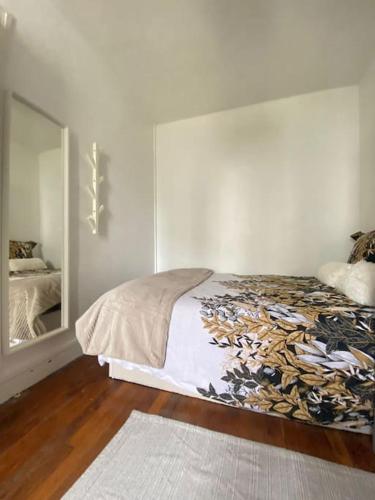une chambre avec un lit et un grand miroir dans l'établissement APP Cozy en plein coeur de Paris, à Paris