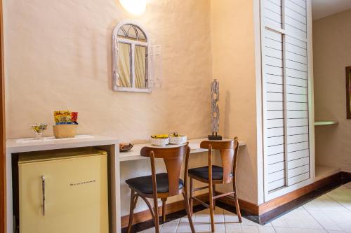 a kitchen with two chairs and a table at Pousada Cavaleiro dos Pireneus in Pirenópolis