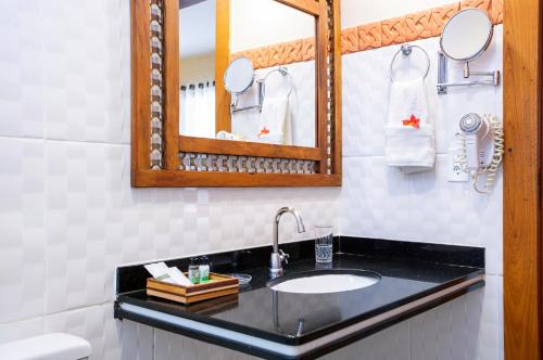a bathroom with a sink and a mirror at Pousada Cavaleiro dos Pireneus in Pirenópolis