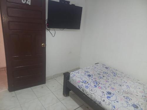 a bedroom with a bed and a flat screen tv at hotel casa del conductor doña silvia in Cartagena de Indias