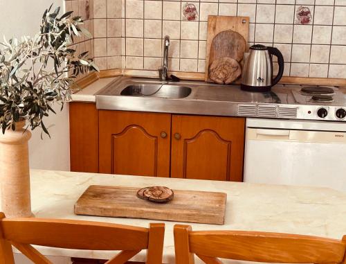 uma cozinha com um lavatório e uma mesa com cadeiras em Studios Fokia Beach em Amoopi