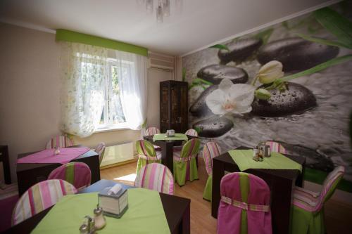 a room with tables and chairs and a flower mural at Hotel Voyage Park in Moscow