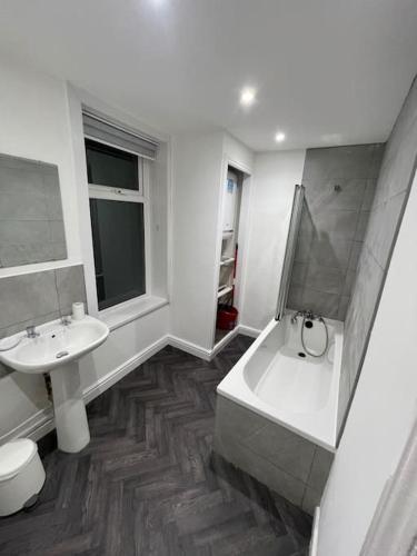 La salle de bains est pourvue d'un lavabo, d'une baignoire et de toilettes. dans l'établissement 212a bell lane, à Bury