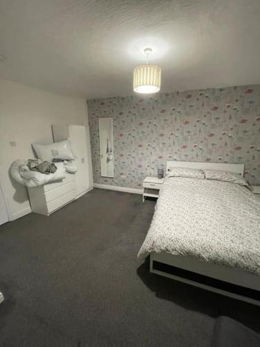 a bedroom with a large bed and a couch at 212a bell lane in Bury