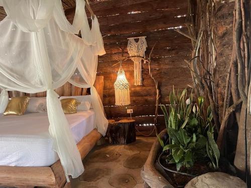 um quarto com uma cama num chalé de madeira em wellgaya ecovillas em Villa Flor