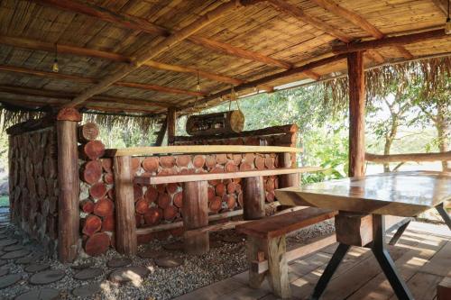 a wooden cabin with a table and a wooden roof at wellgaya ecovillas in Villa Flor