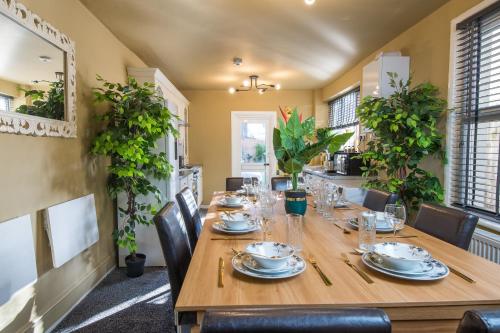 a dining room with a long wooden table and chairs at Stunnning 4 Bed House Hot Tub Sky Tv Pool Table in London