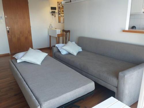a couch with two pillows in a living room at Hermoso departamento en piso 19 in Buenos Aires