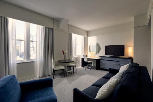 a living room with a couch and a table with a tv at Loews Philadelphia Hotel in Philadelphia
