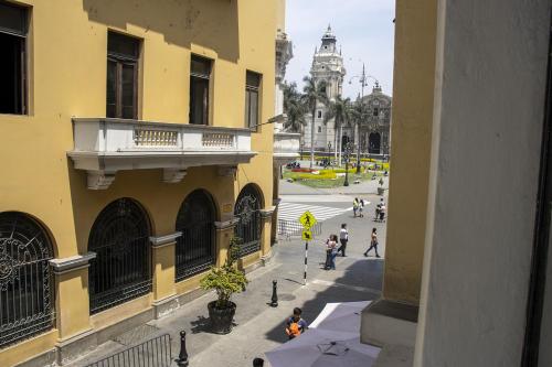 a group of people walking down a street next to buildings at Plaza Mayor Lima in Lima