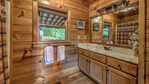 Un baño con bañera, lavabo y espejo. en Lake Vista Lodge, en Blue Ridge