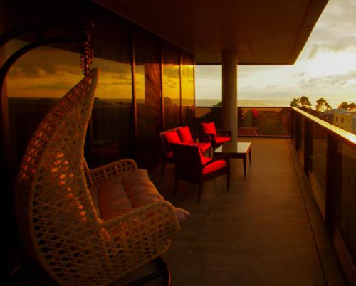 a hammock on a balcony with chairs and a table at Hotel Nobilis Hall in K'obulet'i