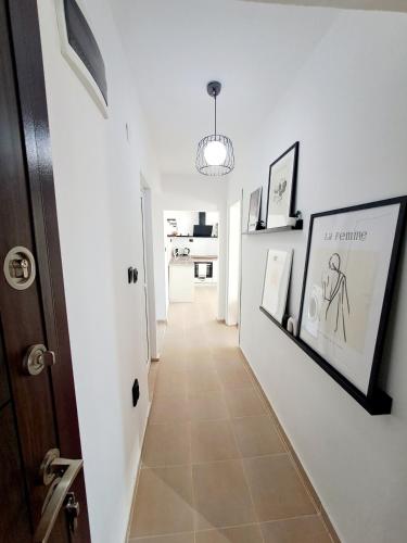 a hallway with white walls and a hallway with pictures at White House Apartments - Boho in Haskovo