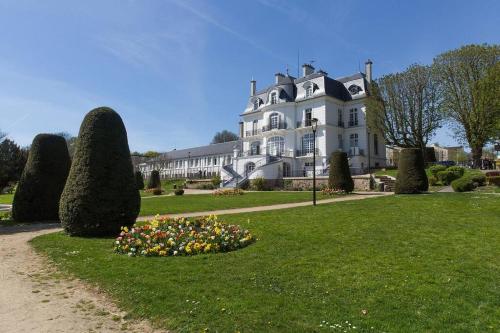 uma grande casa branca com um canteiro de flores na relva em F4 - Duplex spacieux proche d'Orly em Athis-Mons