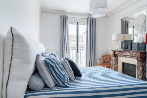 une chambre avec un lit avec des oreillers bleus et blancs dans l'établissement Charmant appartement, à Neuilly-sur-Seine