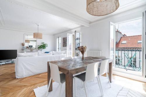 un salon blanc avec une table et un canapé dans l'établissement Charmant appartement, à Neuilly-sur-Seine