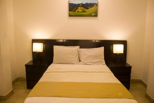 a bedroom with a bed with two lamps on it at Plaza Mayor Lima in Lima