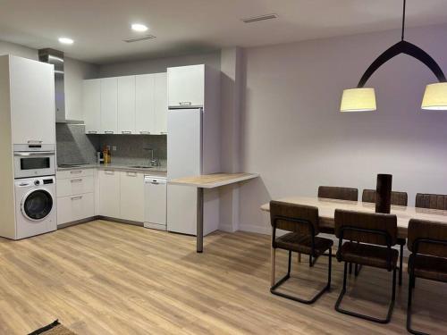 een keuken met witte kasten en een tafel en stoelen bij Apartamento Centro de Valladolid CB in Valladolid