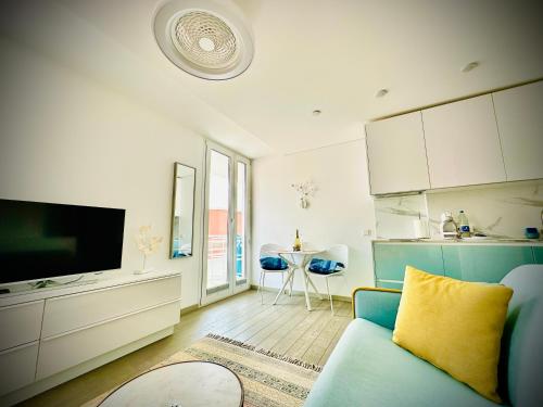 a living room with a blue couch and a kitchen at AMBER APARTMENTS - SUNNY STUDIO in Morro del Jable